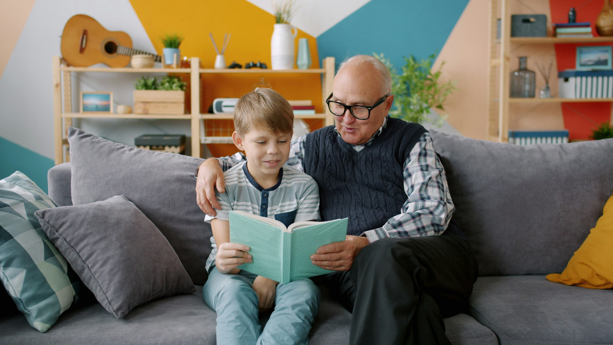 A grandfather reading a book with his grandson